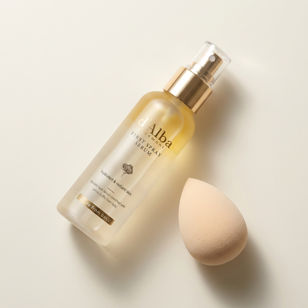 First Spray Serum cerrado junto a una esponja de maquillaje.